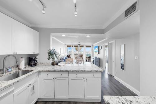 a kitchen with white cabinets and a sink at Aruba - Downtown Waterfront 2x2 Dock & Pool Pet-Friendly in Key West
