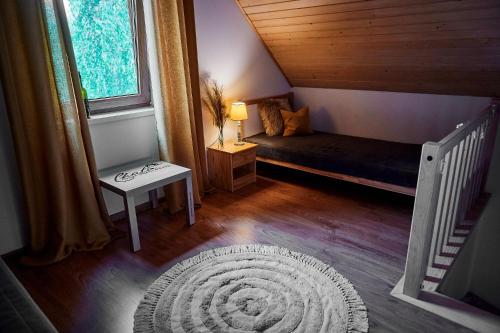 a small room with a bed and a window at Slow Orzechów in Sosnowica