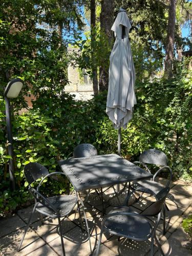 a table and chairs with an umbrella in a yard at Casa vacanze San Rocco in San Venanzo