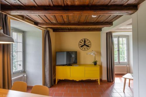 a living room with a tv and a yellow cabinet at BnB SchlafSchloss in Sumiswald