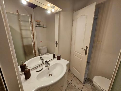 une salle de bain blanche avec un lavabo et des toilettes dans l'établissement La Clé de Voûte, duplex atypique, à Gien