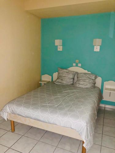 une chambre avec un lit avec un mur bleu dans l'établissement Maison saint cyprien plage, à Saint-Cyprien