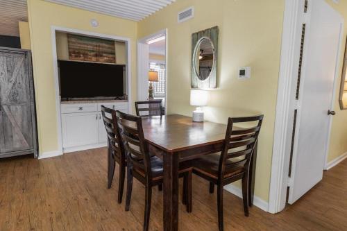 a dining room with a table and chairs and a television at Two Bedroom Villa Sleeps 6 has 2 Queen and 1 King in Pawleys Island