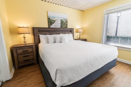 a bedroom with a large bed and two night stands at Two Bedroom Villa Sleeps 6 has 2 Queen and 1 King in Pawleys Island