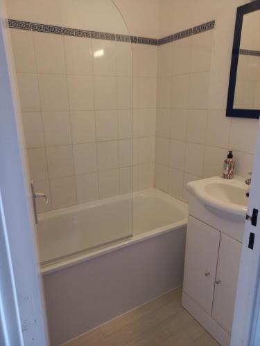 une salle de bain avec une baignoire et un lavabo dans l'établissement Coquet studio 4 pers, piscine,clim mobile, plage a 300 m,à 5min a pied du Lydia, au Barcarès