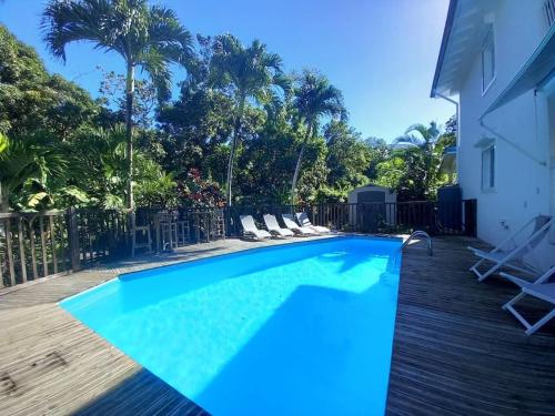 a swimming pool with blue water in a yard at Ti Paradis Gîte à 200 m plage de Grande Anse in Deshaies