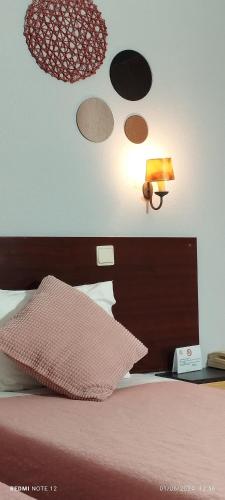 a bedroom with a bed with a lamp and planets on the wall at Hotel Alnacir in Faro