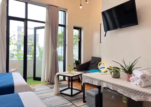 ein Hotelzimmer mit einem Bett und einem TV in der Unterkunft Nguyễn Villa Royale in La Gi
