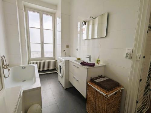 une salle de bain avec un lavabo et une machine à laver dans l'établissement Appartement typique et confortable - Voltaire, à Paris