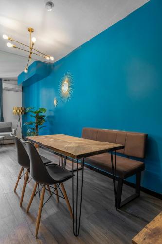 une salle à manger avec un mur bleu, une table et des chaises dans l'établissement Au cœur du Vieux-Port, à Marseille