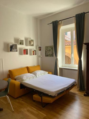 Cama en habitación con sofá y ventana en La casa di Remo, en Roma