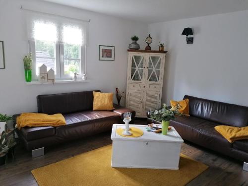 sala de estar con sofás de cuero y mesa de centro en Ferienhaus in Erlbach mit Grill und Terrasse, en Erlbach