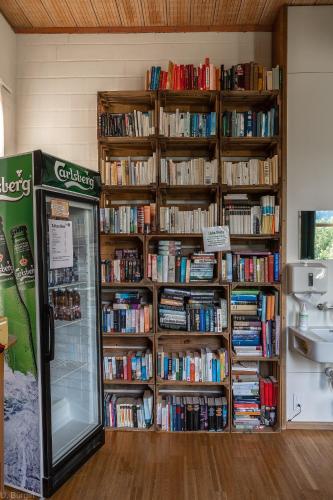 a book shelf filled with books next to a refrigerator at BnB SchlafSchloss in Sumiswald