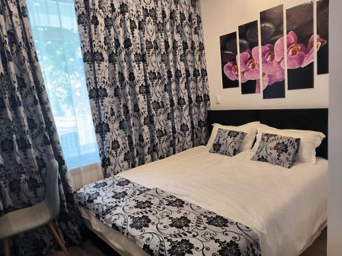 a bedroom with a bed with black and white curtains at Bulevard Residence in Brăila