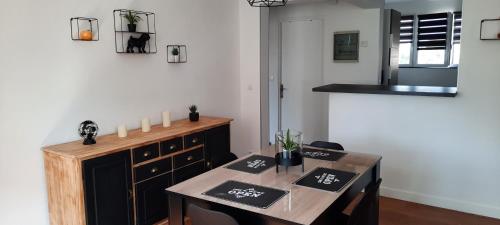 a dining room with a table and chairs and a kitchen at Appartement Centre ville proche gare in Dunkerque