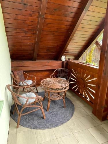 a patio with two chairs and a table on a porch at Globasnitzer Cottage am Fuße der Petzen in Globasnitz