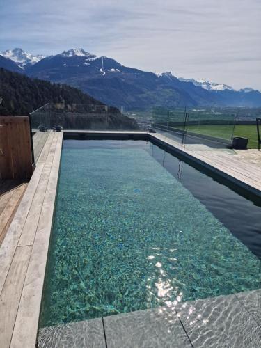 a pool of water with mountains in the background at Studio Le Carnotzet Tchiko minimum 2 nights Special weekly and monthly prices in Savièse