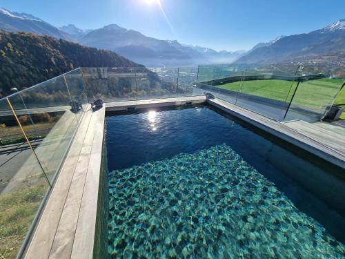 a pool of water with mountains in the background at Studio Le Carnotzet Tchiko minimum 2 nights Special weekly and monthly prices in Savièse