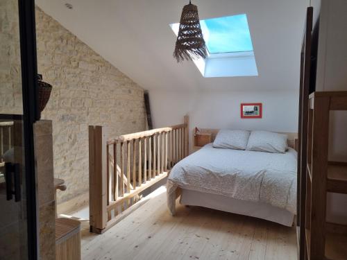 une chambre avec un lit et une lucarne dans l'établissement les gites d'Adirya, à Saint-Mard