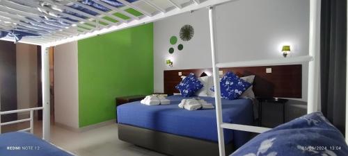 a bedroom with a bed with blue sheets and blue pillows at Hotel Alnacir in Faro