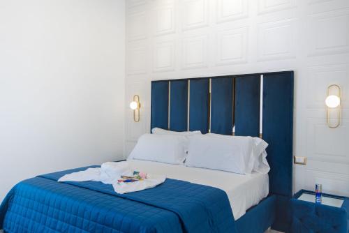 a blue and white bed with two towels on it at Red Queen Herculaneum in Ercolano