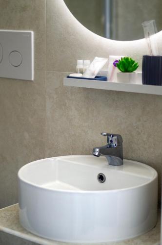 a white sink in a bathroom with a mirror at Red Queen Herculaneum in Ercolano