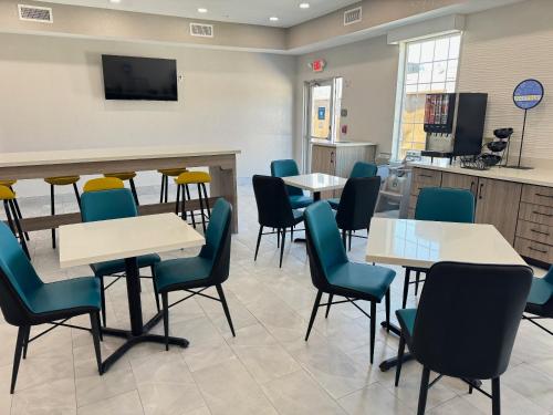 a waiting room with tables and chairs at Sonesta Essential La Porte in La Porte