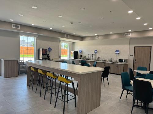 a large room with a large counter with chairs at Sonesta Essential La Porte in La Porte