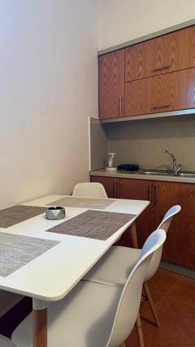 a kitchen with a white table and two chairs at Peçi Apartments Gjirokastër in Gjirokastër