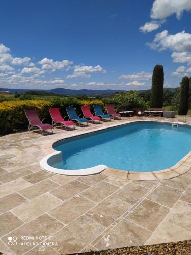 a swimming pool with chairs and a table at La maison de Nazig in Pertuis