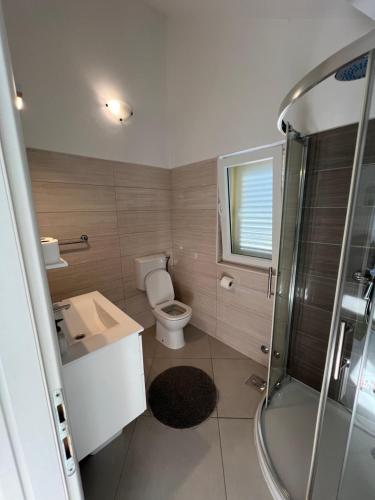 y baño con aseo, lavabo y ducha. en Sunce apartments en Grebaštica
