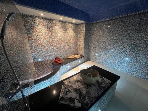 a bathroom with a tub and a shower with a bowl at HAMILTON Agadir in Agadir