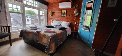 ein Schlafzimmer mit einem Bett in einem Zimmer mit Fenstern in der Unterkunft Bed & Breakfast Moments in Schagen