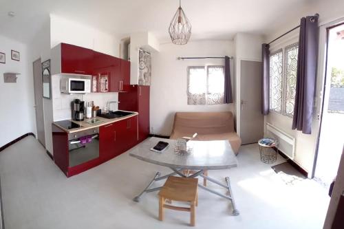- une cuisine avec des placards rouges et une table dans une pièce dans l'établissement Sunset Cagnes, à Cagnes-sur-Mer