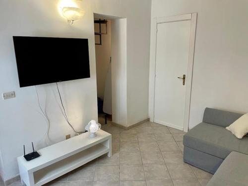 a living room with a couch and a flat screen tv at La casa al mare in Ostuni Costa Merlata
