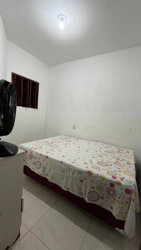 una camera con un letto in una stanza con un ventilatore di Casa farolândia ad Aracaju