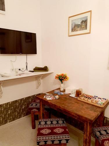 a room with a wooden table and a tv at Sebilhan Apart Hotel in Sarajevo