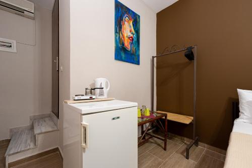 Habitación con baño pequeño con nevera blanca. en Sante en Kallithea Halkidikis