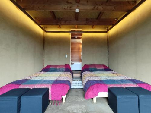 Dos camas en una habitación pequeña con rosa y azul en Kita Karuizawa Morino Takibi NO5 en Tsumagoi