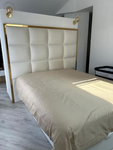 - un lit dans une chambre avec une tête de lit blanche dans l'établissement belle maison avec piscine chauffée sans vis-à-vis, à Caudebec-lès-Elbeuf