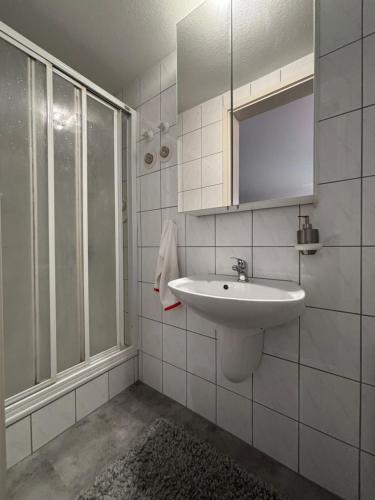 un bagno bianco con lavandino e doccia di Doppelzimmer in Stuttgart-Birkach - Nähe Musicals im SI-Zentrum, Messe, Flughafen, Uni Hohenheim a Stoccarda