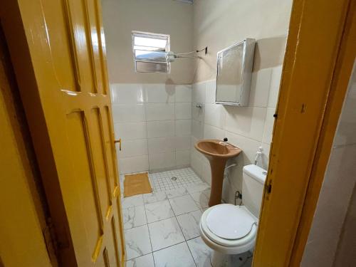 a small bathroom with a toilet and a sink at Casa Praia Grande in Praia Grande