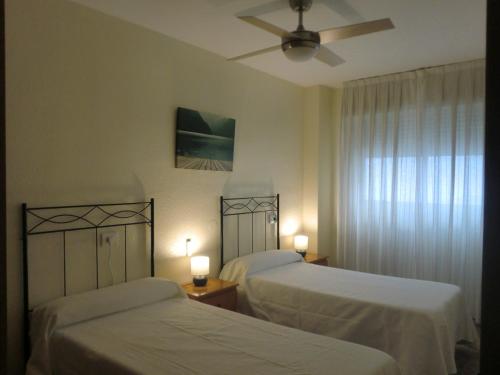 een slaapkamer met 2 bedden en een plafondventilator bij Piso La Pista Alcora in Alcora