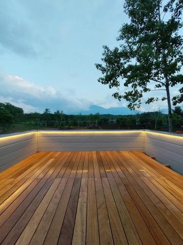 a wooden deck with a tree in the background at Kita Karuizawa Morino Takibi Dogs OK! in Tsumagoi