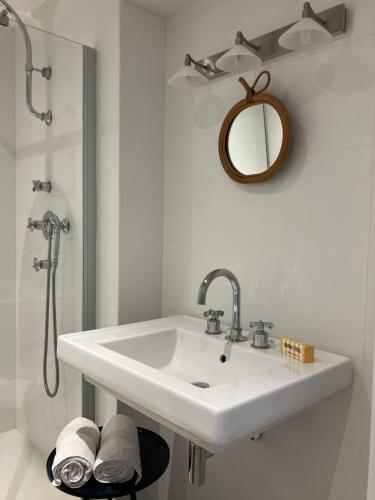 une salle de bain blanche avec un lavabo et un miroir dans l'établissement Ker Heol, à Saint-Malo