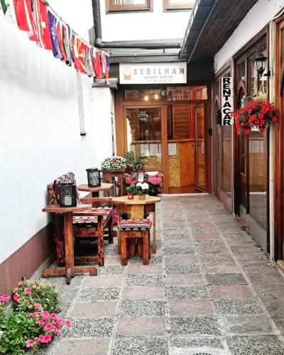 a patio with tables and chairs in front of a building at Sebilhan Apart Hotel in Sarajevo