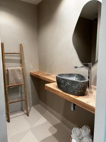 een badkamer met een zwarte wastafel op een houten plank bij W Y C K - E N D boutique b&b in Maastricht