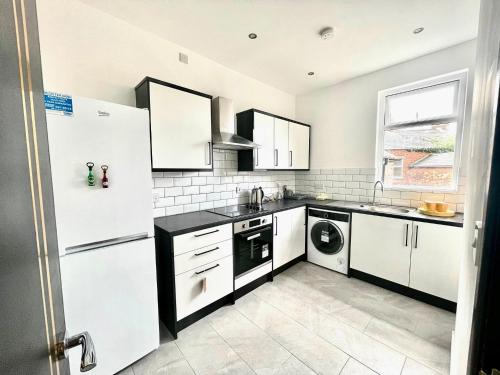 a kitchen with white cabinets and a washer and dryer at Entire YellowApt near Belfast City Centre - Free parking - Up to 3 guests - 2 beds in Belfast