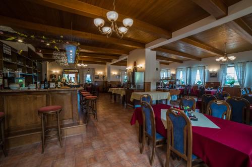 a restaurant with tables and chairs and a bar at Hotel Elsyn Dvůr in Stachy