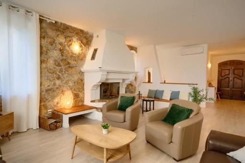 un salon avec deux chaises et une cheminée dans l'établissement 06Q - Biot beautiful provencal villa with swimming pool, à Biot